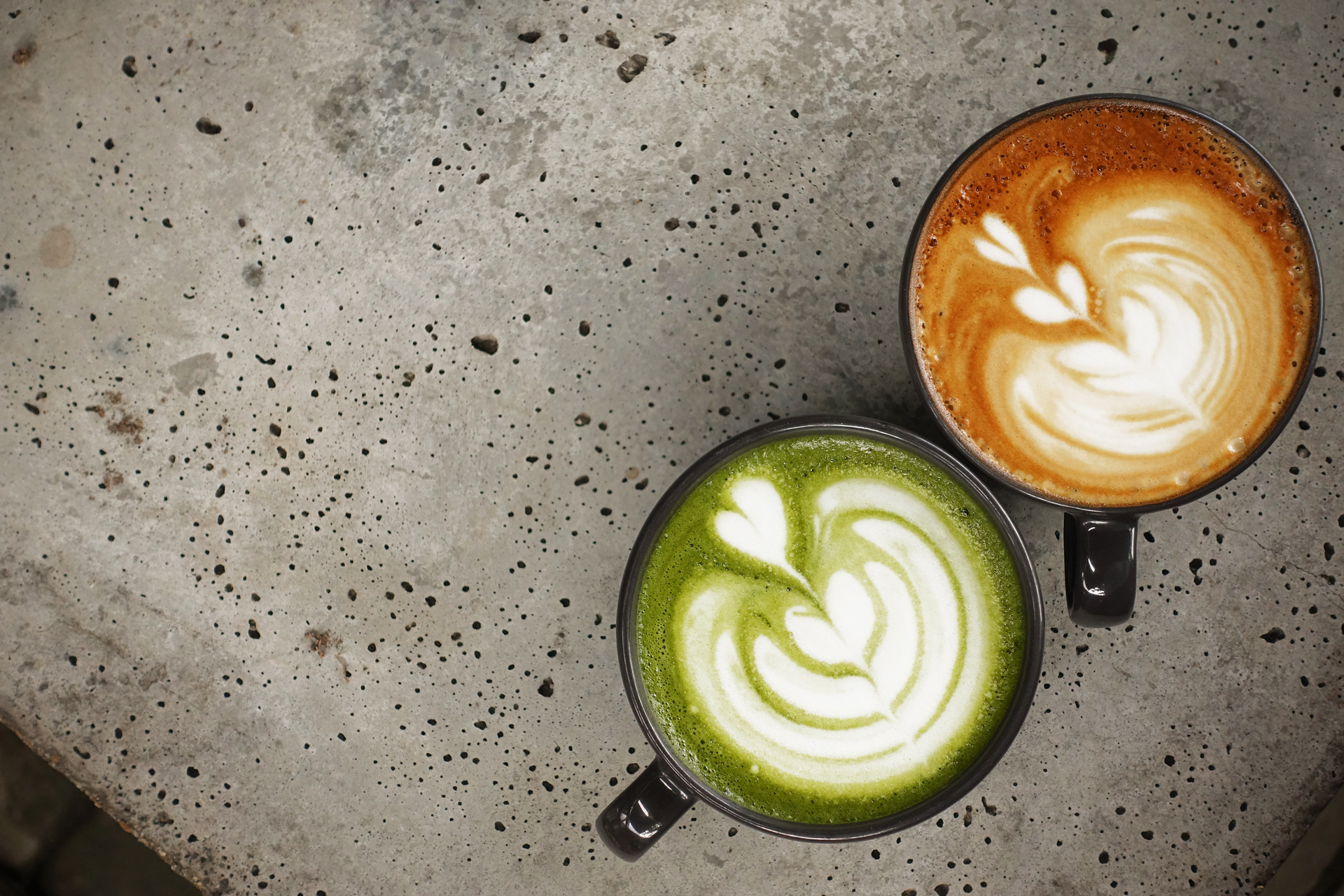 Matcha latte and coffee with latte art on a cafe tableMatcha latte and coffee with latte art on a cafe table